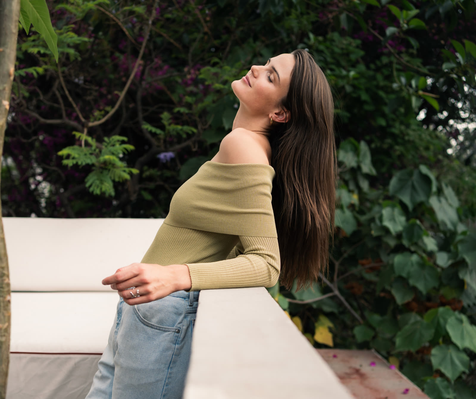 Tess bathed in soft light against lush greenery, feeling alive.