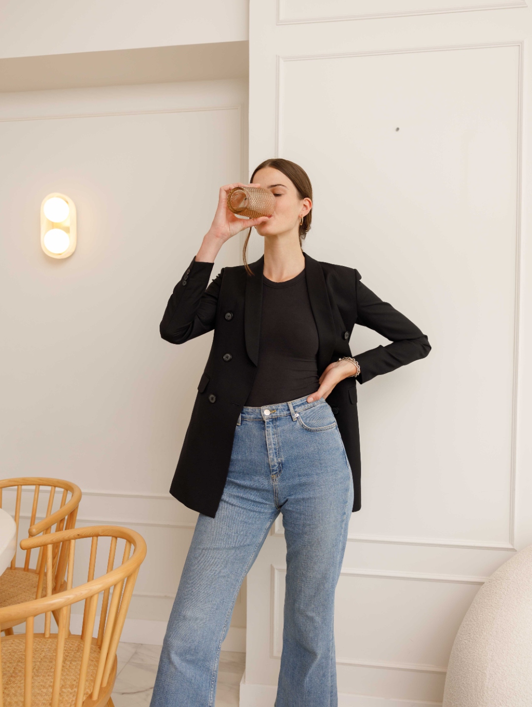Tess standing tall in a black blazer and jeans, rebuilt and grounded.