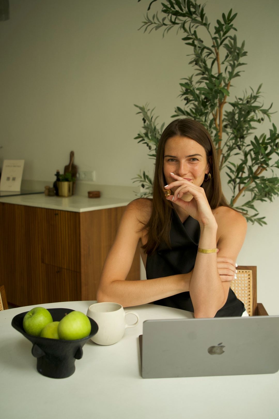 Tess at the table with fresh apples and coffee, calm morning setup.